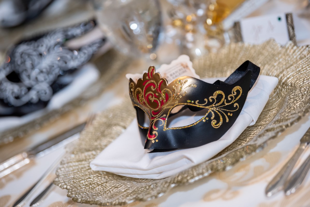 Venetian mask giveaway on wedding reception tables at Vancouver Club