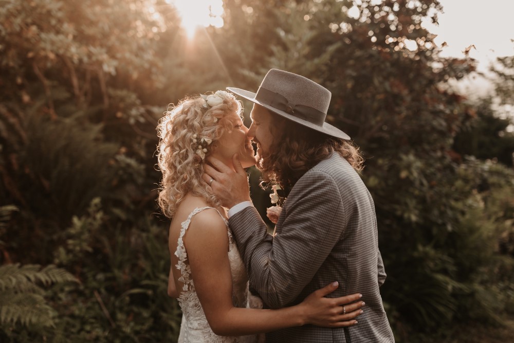 Golden Hour bride and groomm about to kiss holding each other with trees in the background