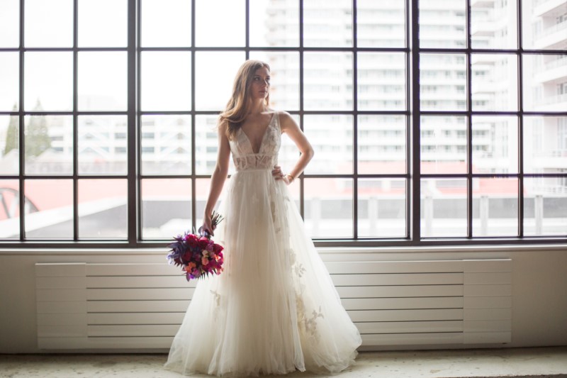 Bride in front of window in Willowby by Watters gown