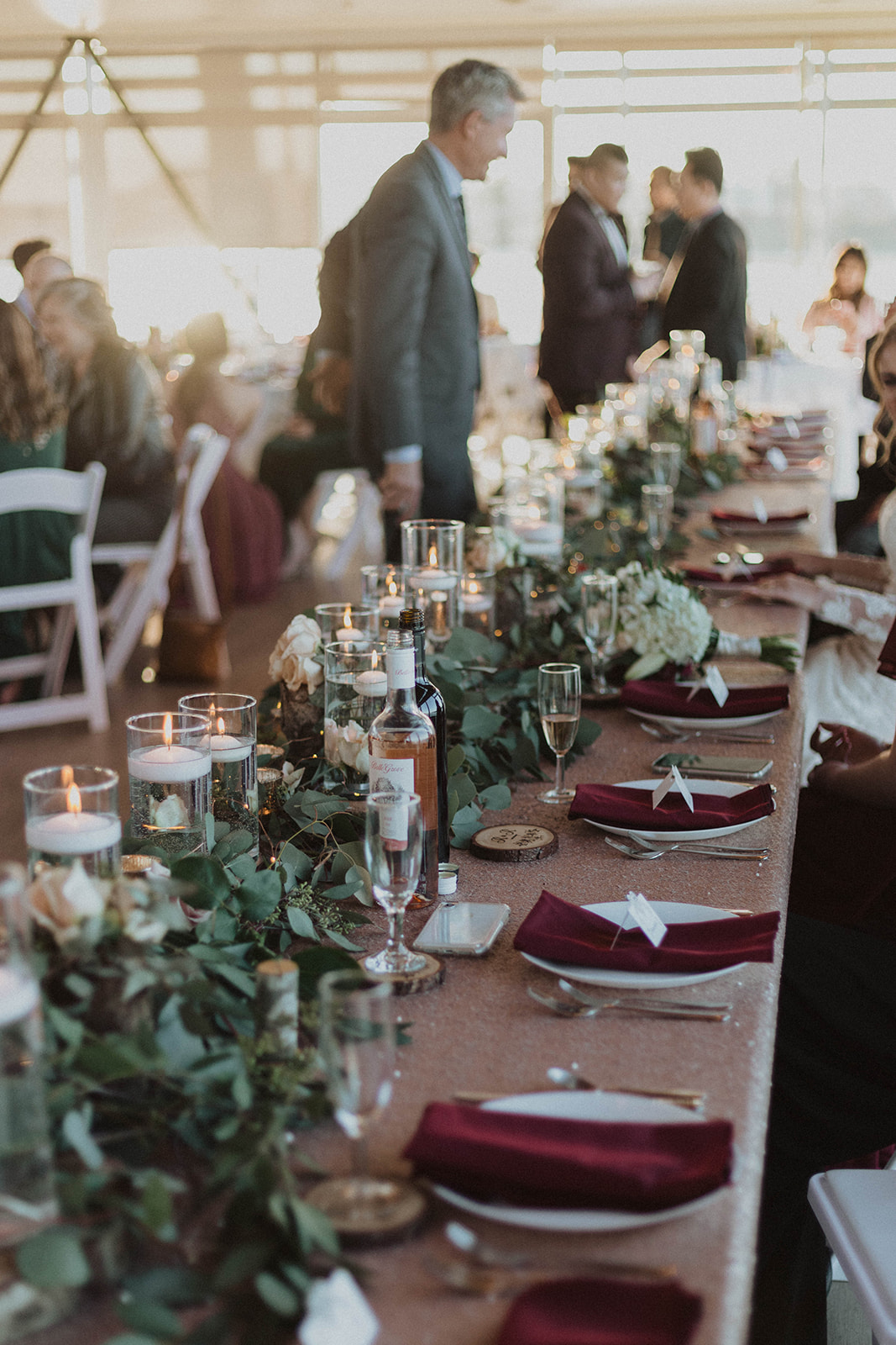 UBC Boathouse Wedding head table decor floating candles, eucalyptous and log rounds with blush pink roses