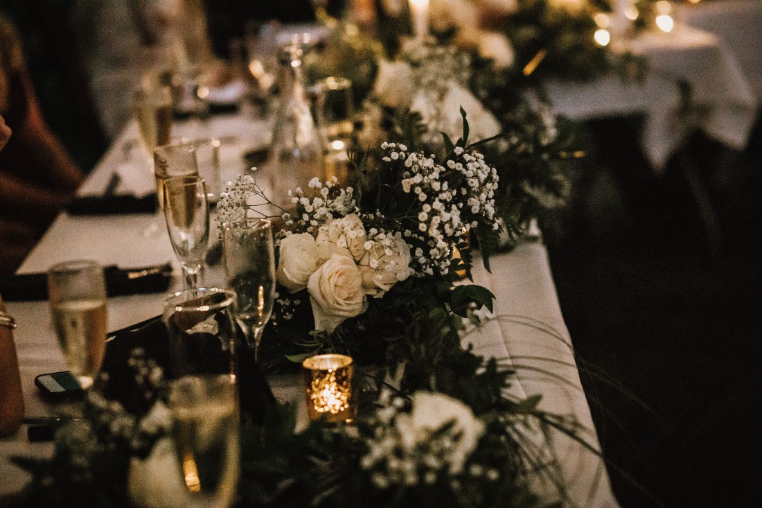 Wedding Head Table with roses, greenery and candles by Flourish Events