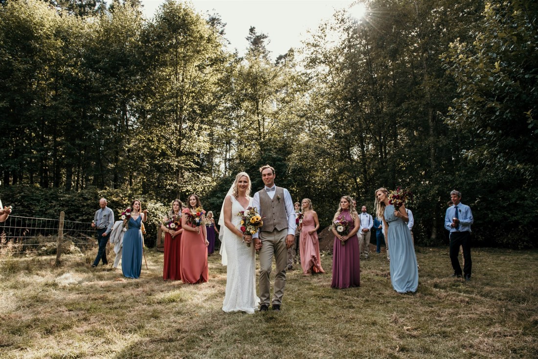 Newlyweds and wedding party in farm field on Vancouver Island