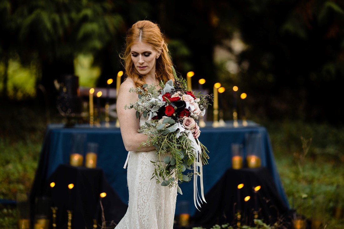 Fall Hues Bride in front of table full of candlesticks by Three Cheers Events Vancouver