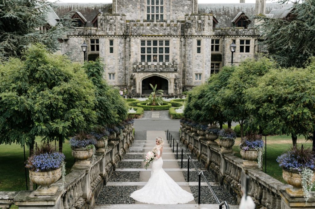 Bride goes down the stairs at Hatley Castle Vancouver Island by Ross Kyker Photography