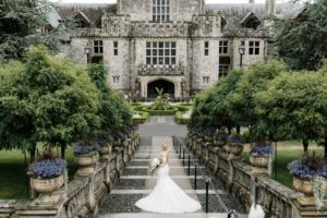 Bride goes down the stairs at Hatley Castle Vancouver Island by Ross Kyker Photography