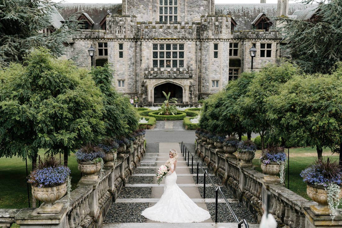 Bride goes down the stairs at Hatley Castle Vancouver Island by Ross Kyker Photography