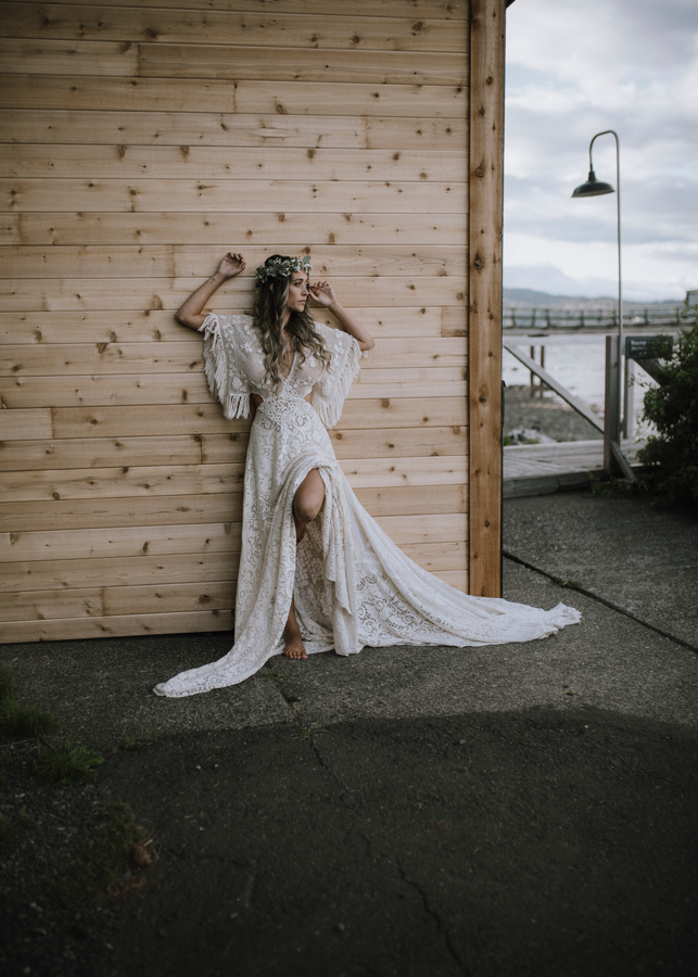Bride against Dolphin's Resort wall in flowing lace Reclamation gown
