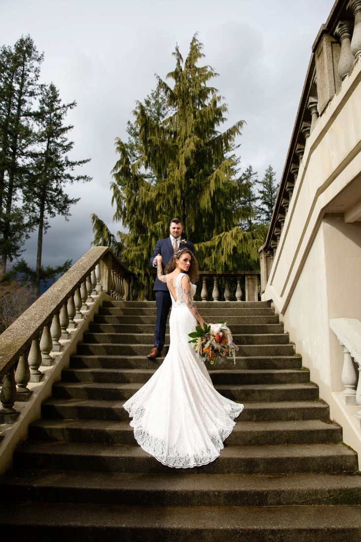 Newlyweds stand together on the stunning stairway at Swaneset Vancouver