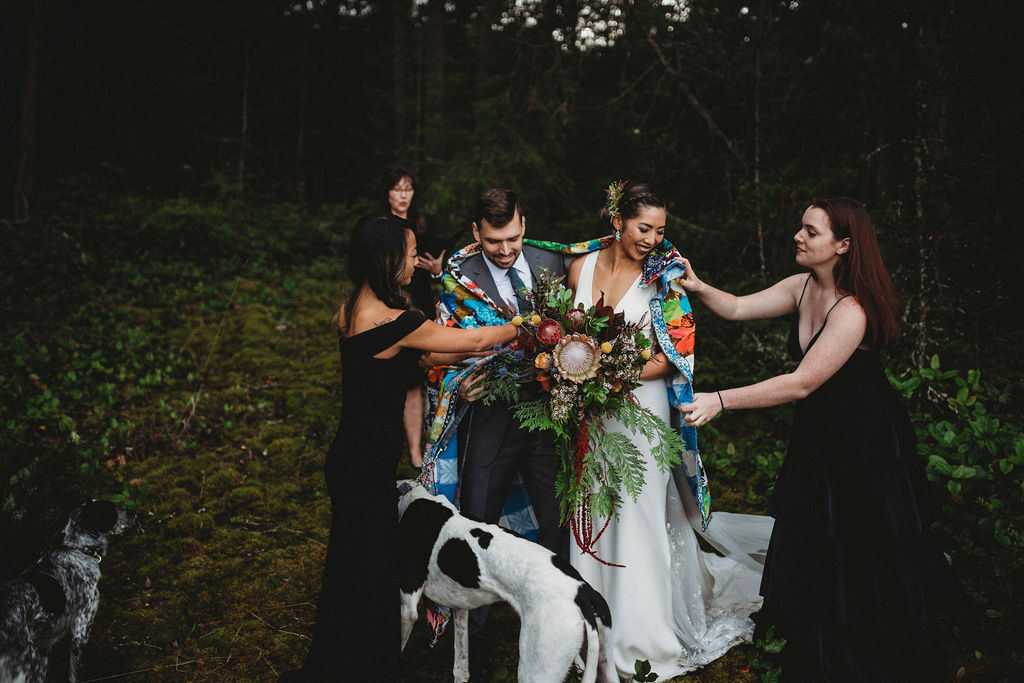 Changing Plans Anastasia Photography bridal party helps put quilt around couple