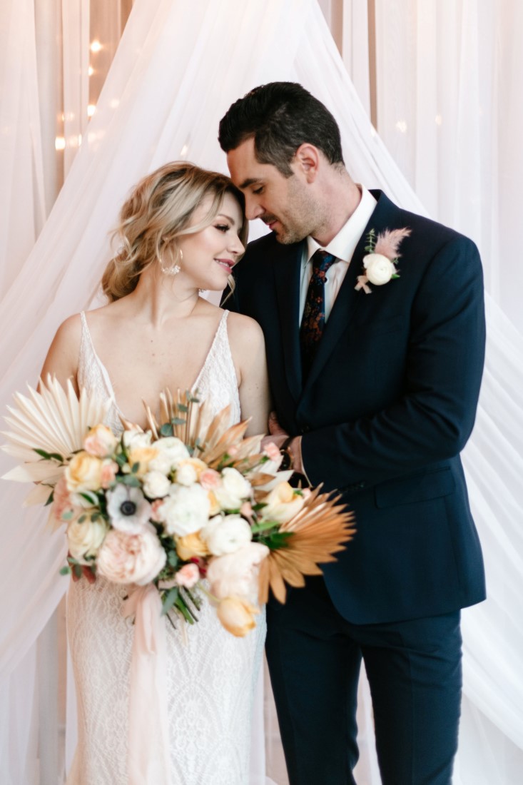 Love Letter Newlyweds stand in front of white drapery at Dolphin's Resort