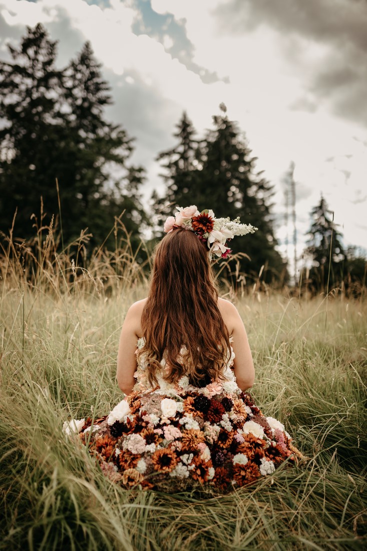 Flirty Floral Gown bride runs through field of flowers on Vancouver Island