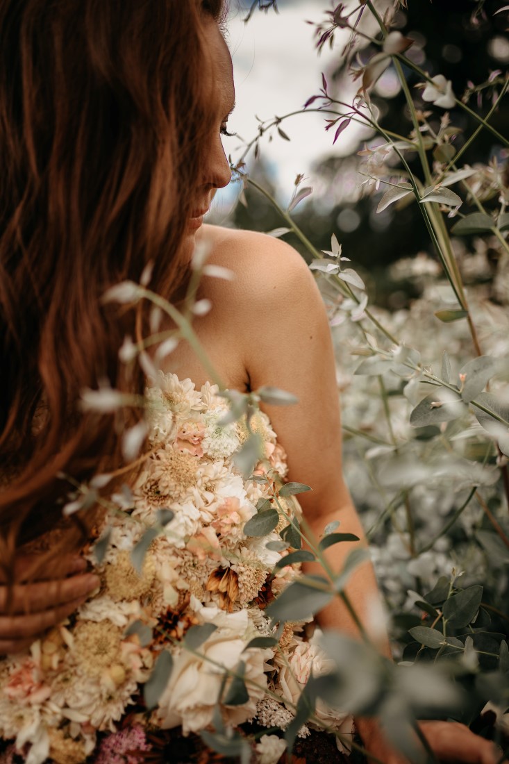 Flirty Floral Gown bride runds through meadow of flowers on Vancouver Island