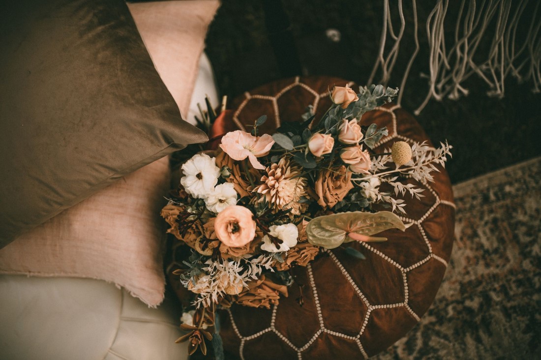 Bohemian Summer Sweetheart Table with peach flowers and pillow seating