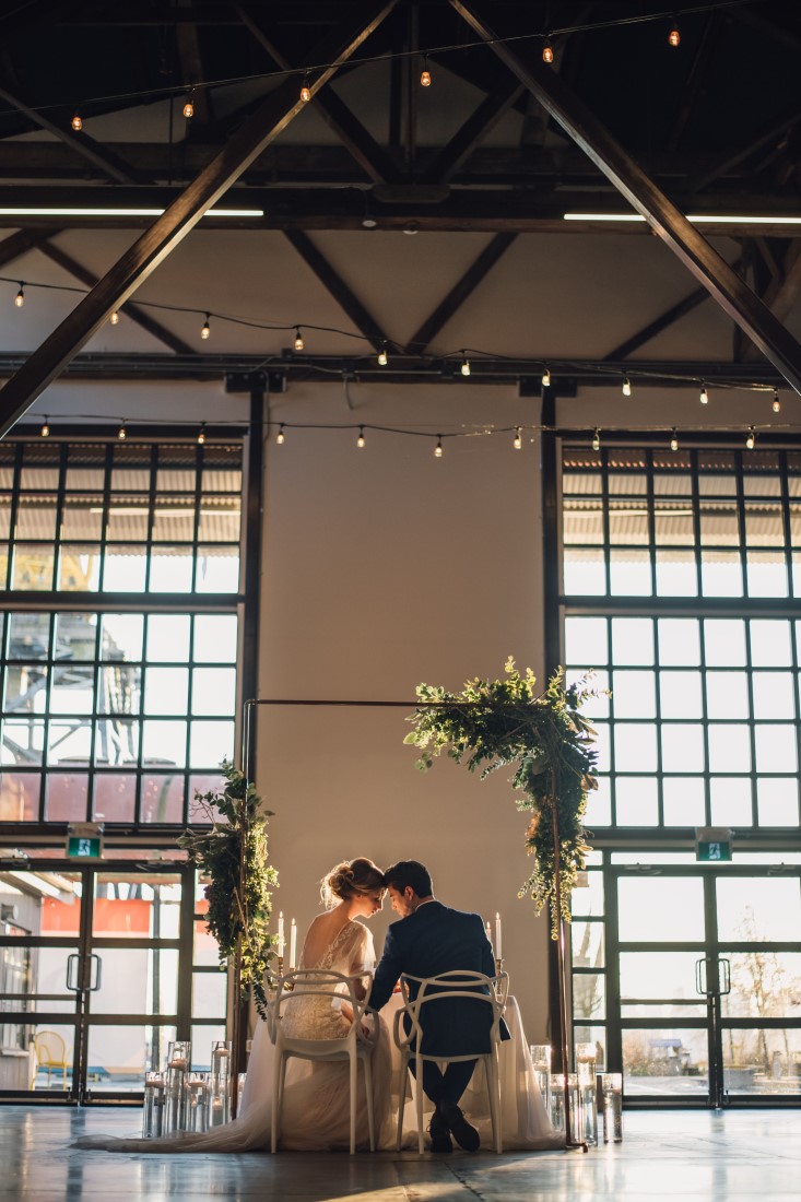 Laura Olson Photography Back of couple at Table Golden Hour Wedding at The Vancouver Shipyards