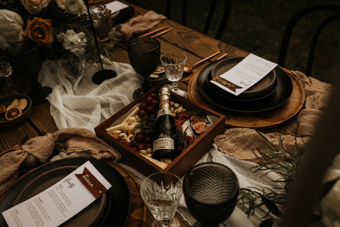 Champagne resting in a box on outdoor farm table wedding reception at Keating Farm