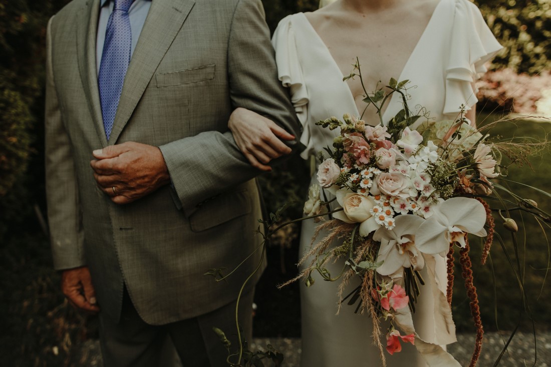 Backyard Bliss bride holding bouquet by The Wild Bunch in Vancouver