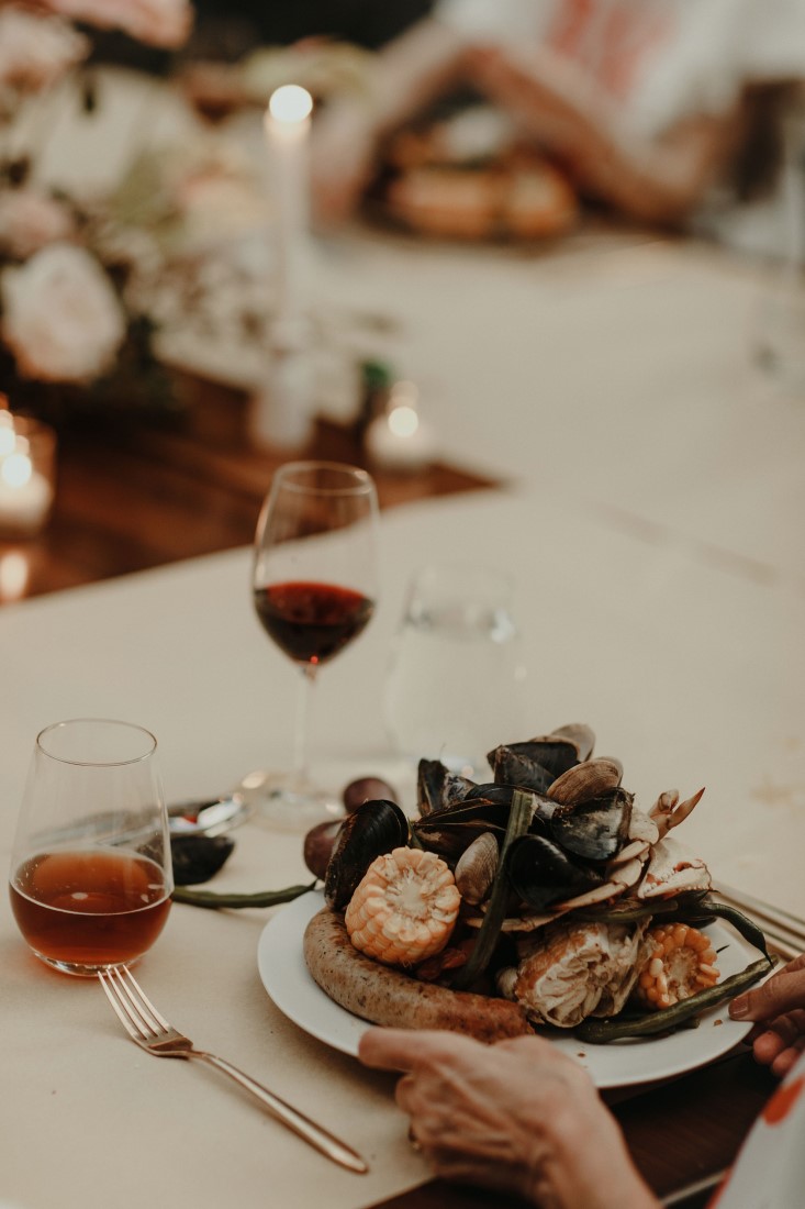 Backyard Bliss guests are seated at dinner table by Salt and Earth Catering Vancouver
