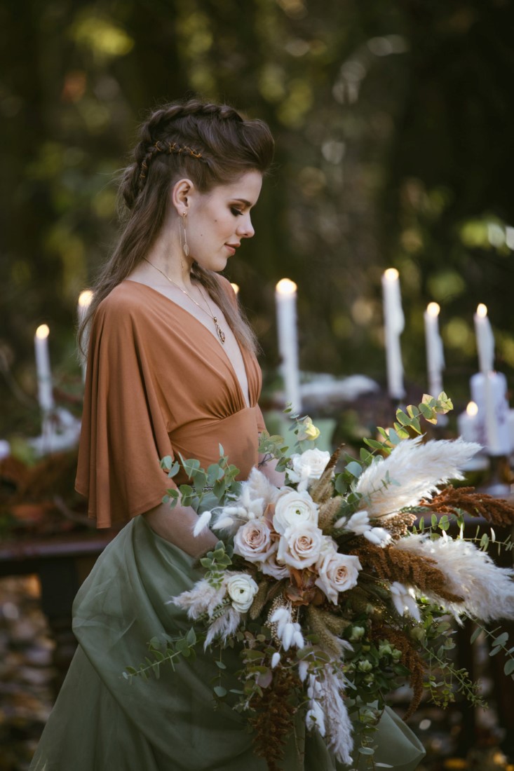 Bride wears rust gown with green skirt in Vancouver forest