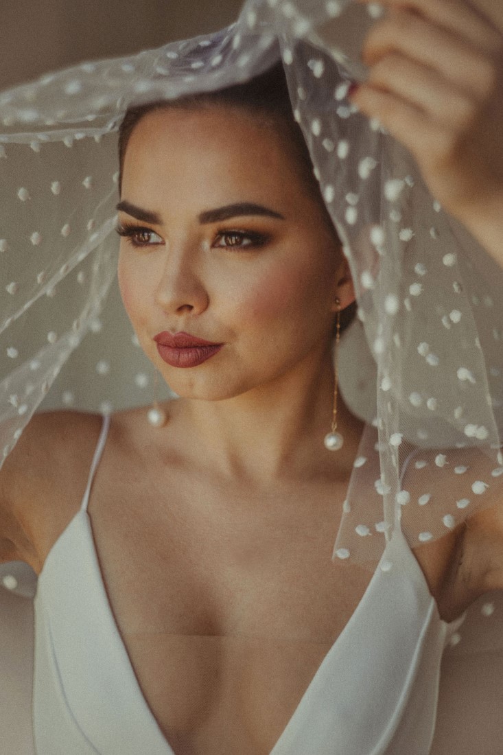 Bride lifts polka dot veil 