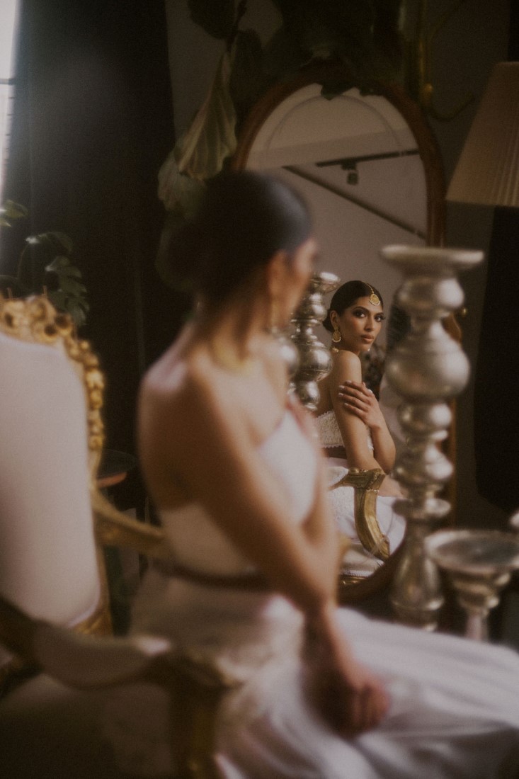 Bride looks into mirror at her reflection