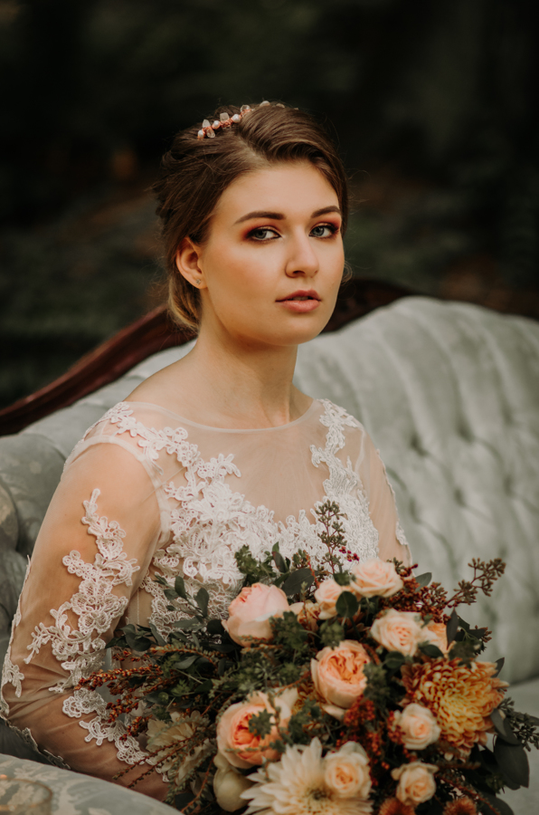 Bride sits on blue vintage couch in the Vancouver Island rainforest 