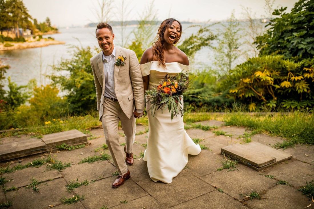 Bride and Groom walk along Vancouver beach edge