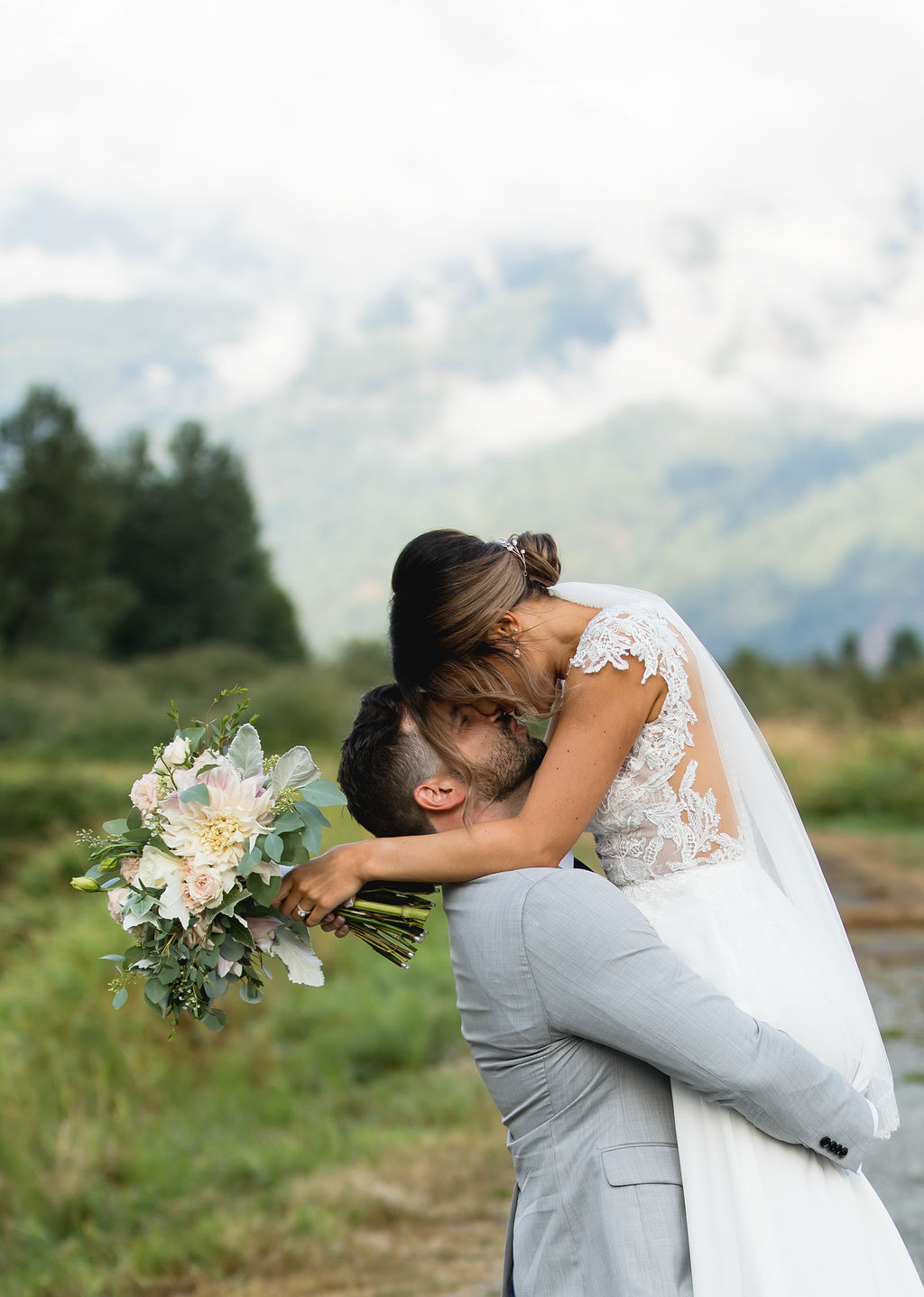 Groom lifts bride up at Pitt Lake