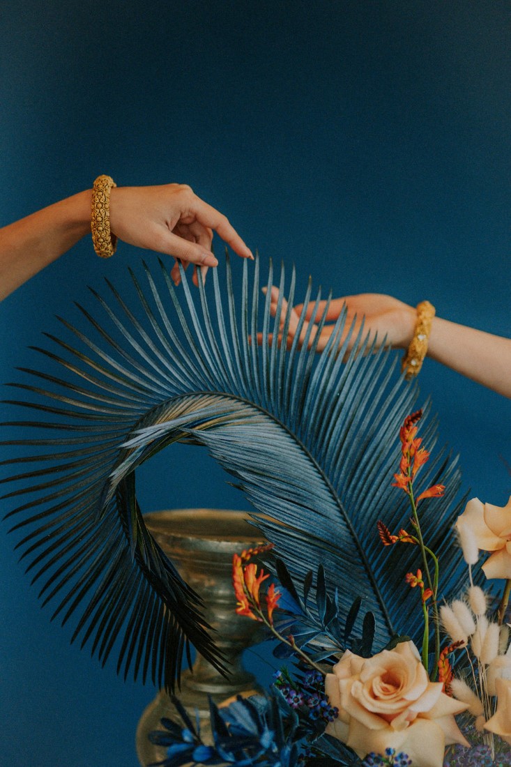 Brides hands over tea blue tropical leaf 