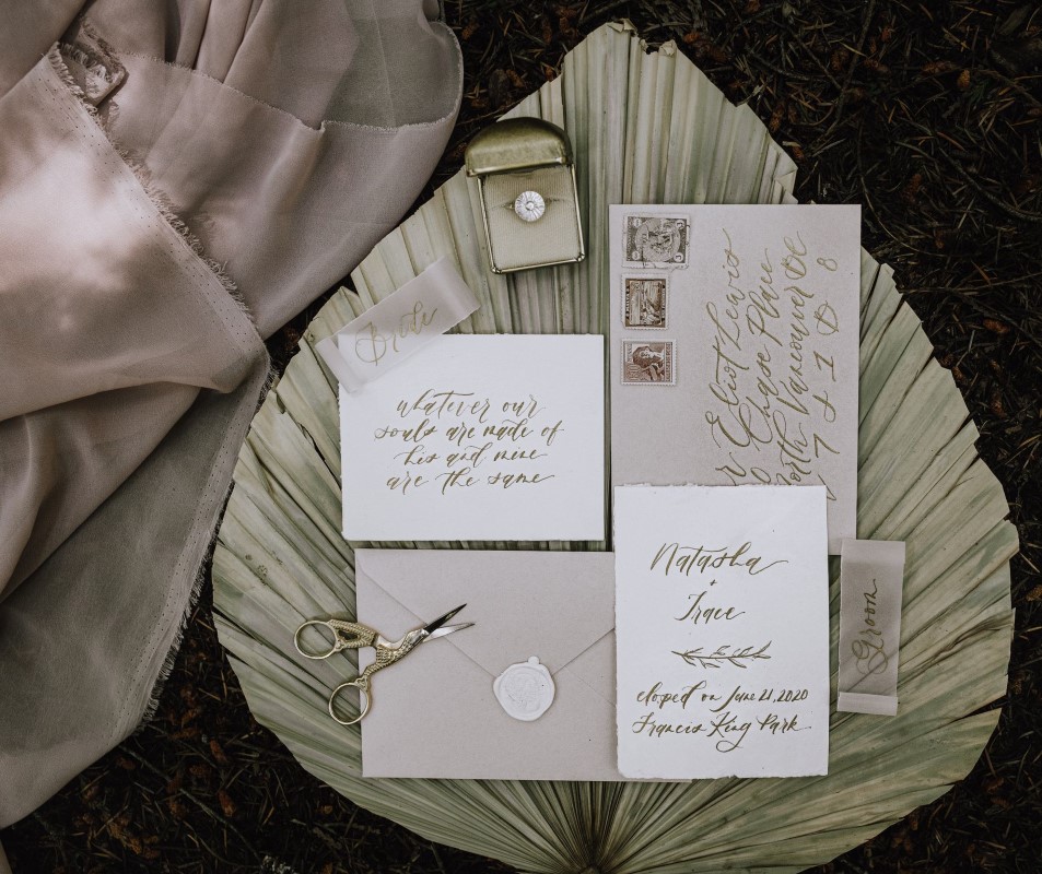 Invitation suite sits on large pampas leaf