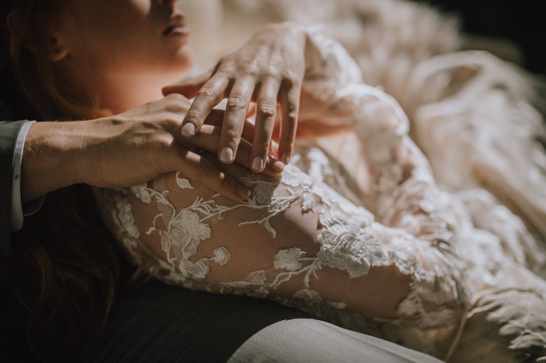 Newlyweds hold hands over bride's She Wore Flowers Gown