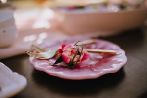 Pink rose bud on pink wedding reception plate