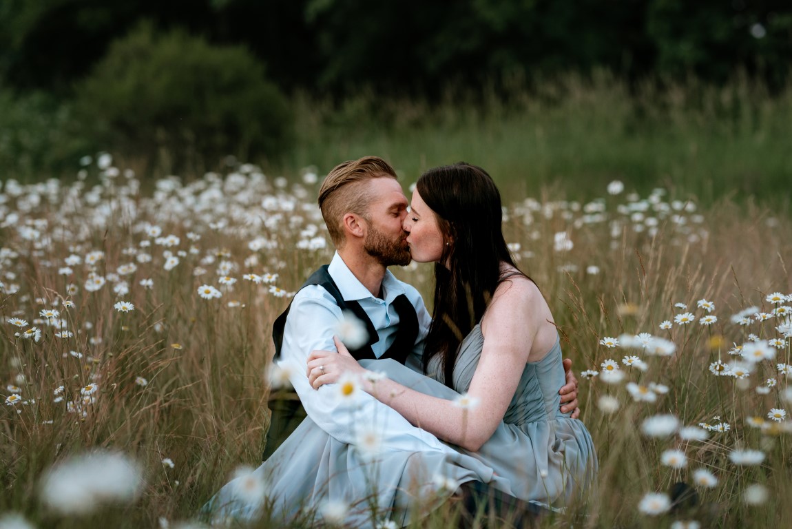 Newlyweds kiss surrounded by BC Mountain flowers