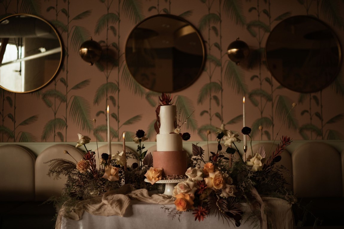 Playful + Pink wedding cake surrounded with flowers