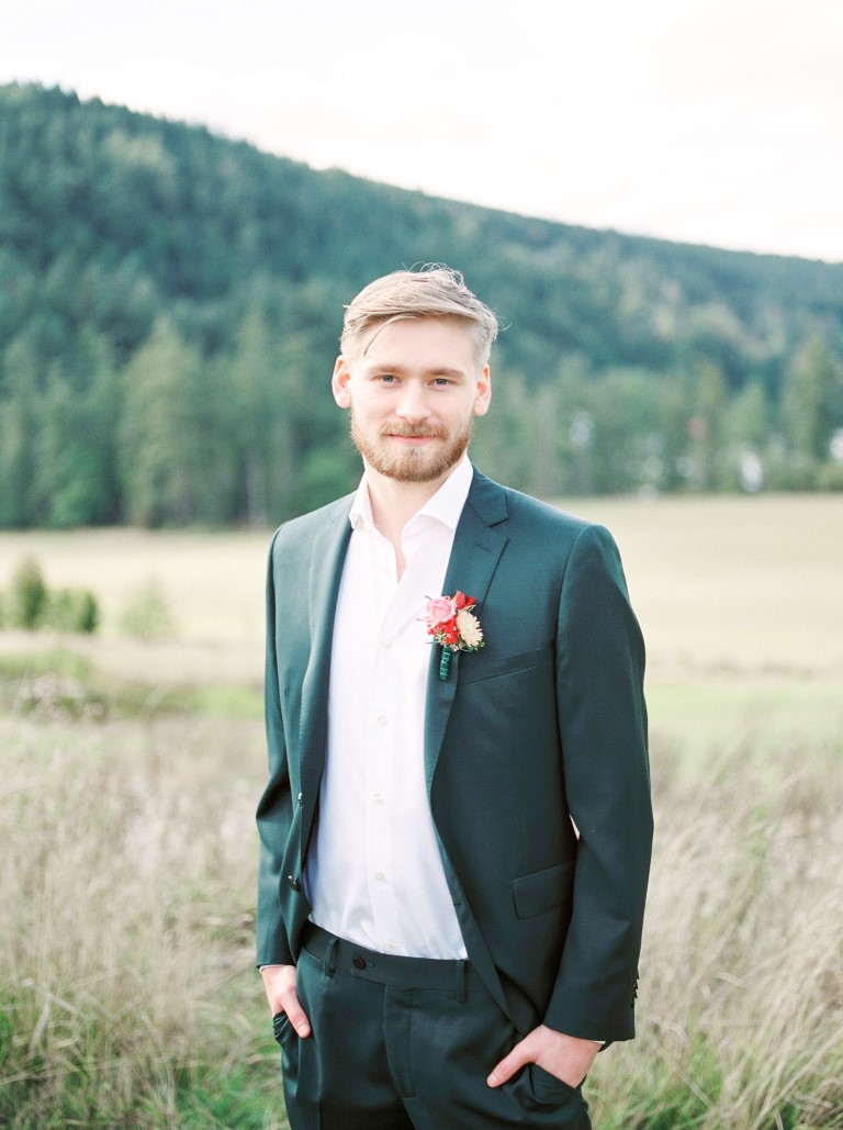 Groom in emerald green suit in Vancouver Island field