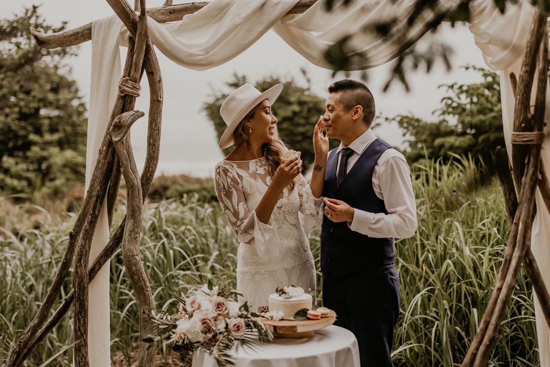 Tofino Eloping Couple share cake on the beach