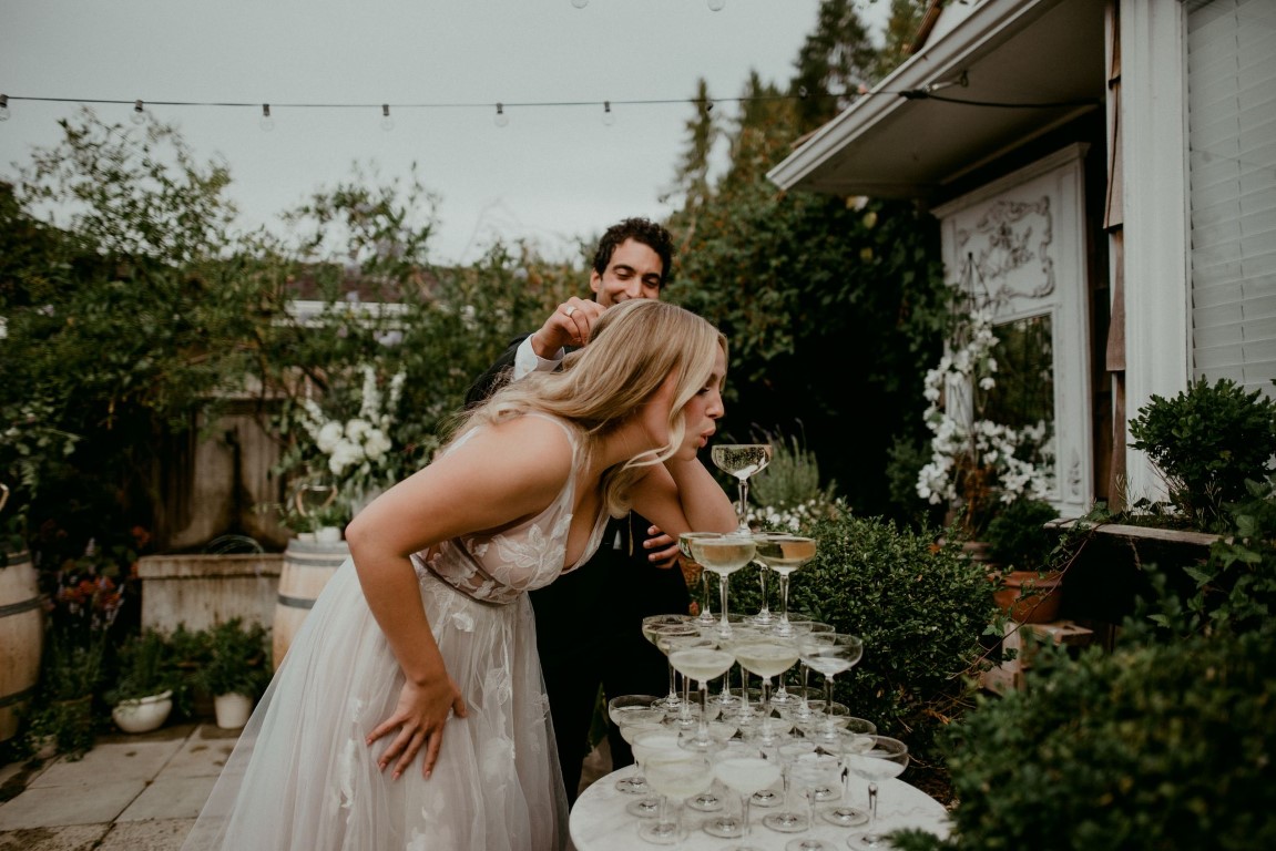 Bride sips from champagne tower by Dallas and Sabrina