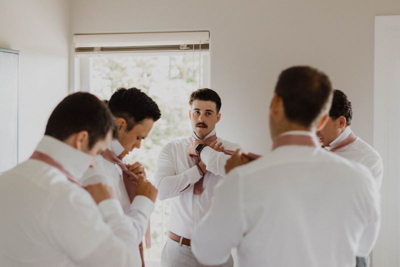 Groom and Groomsman putting on ties at Cowichan Valley Wedding