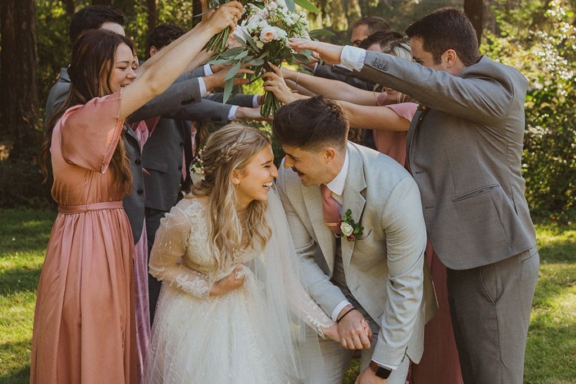 couple walks under bridal party arm bridge
