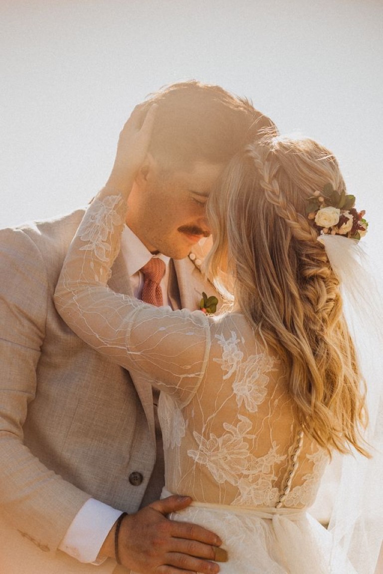 bride and groom hold each other at golden hour