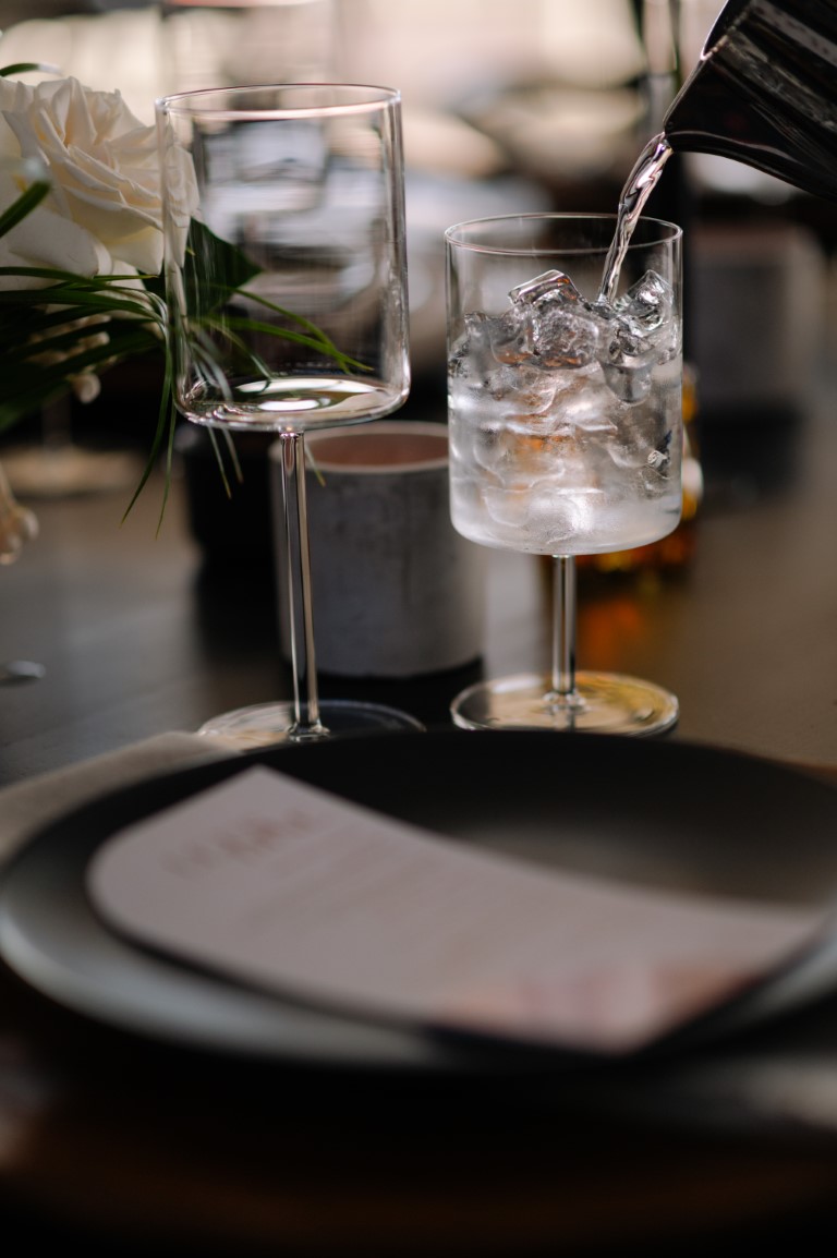 wine glass reflets on black tables and place settings