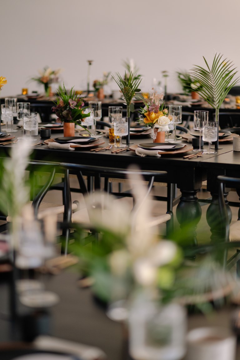 gorgeous wedding reception table settings and decor in black and palm leafs