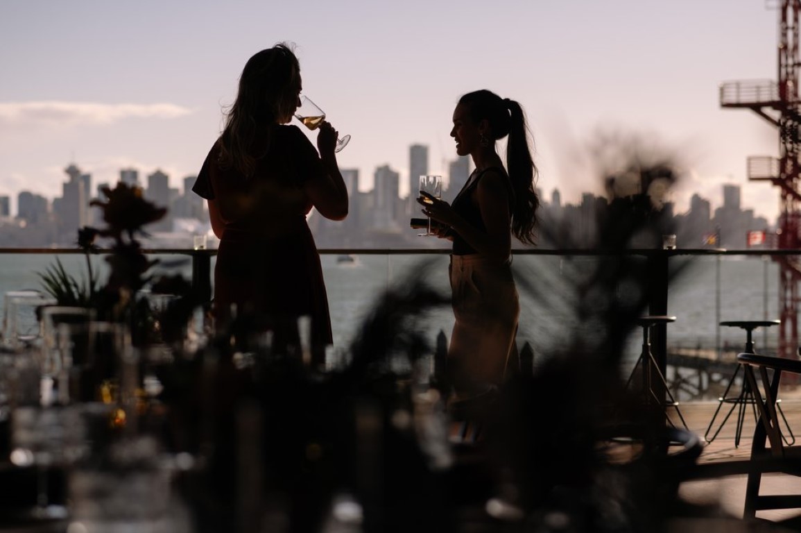 Guests eat canapes against Vancouver skyline at The Pologon