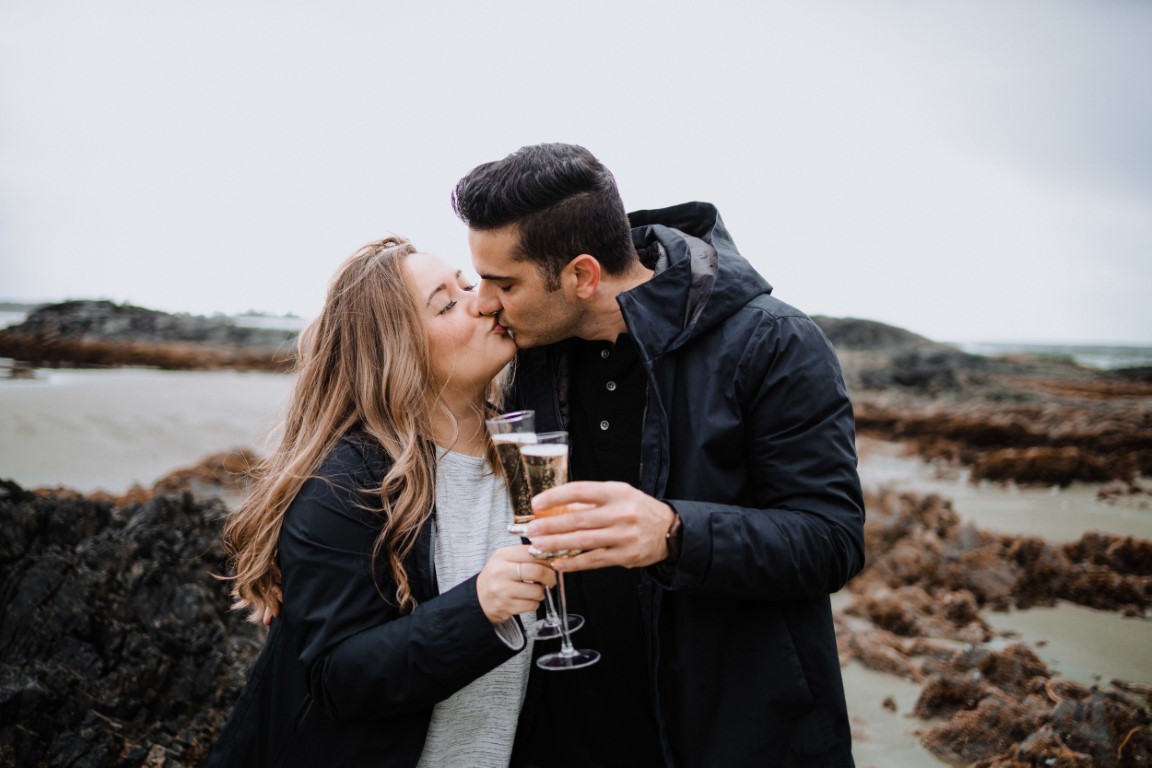 Couple share champagne on Tofino beach