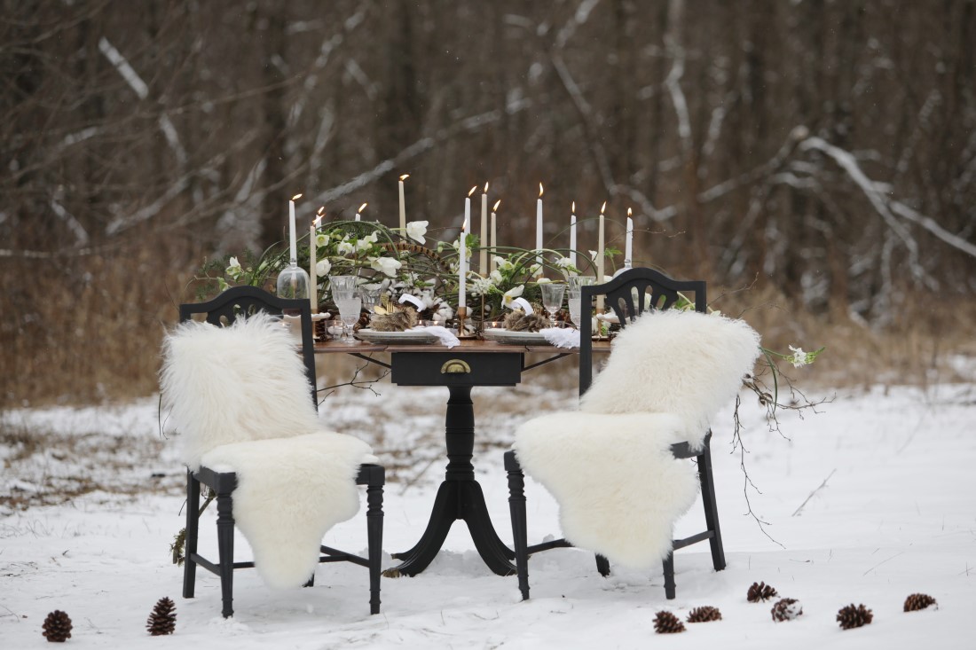 Winter sweetheart table with white faux fur, candlesticks and white roses with pine cones