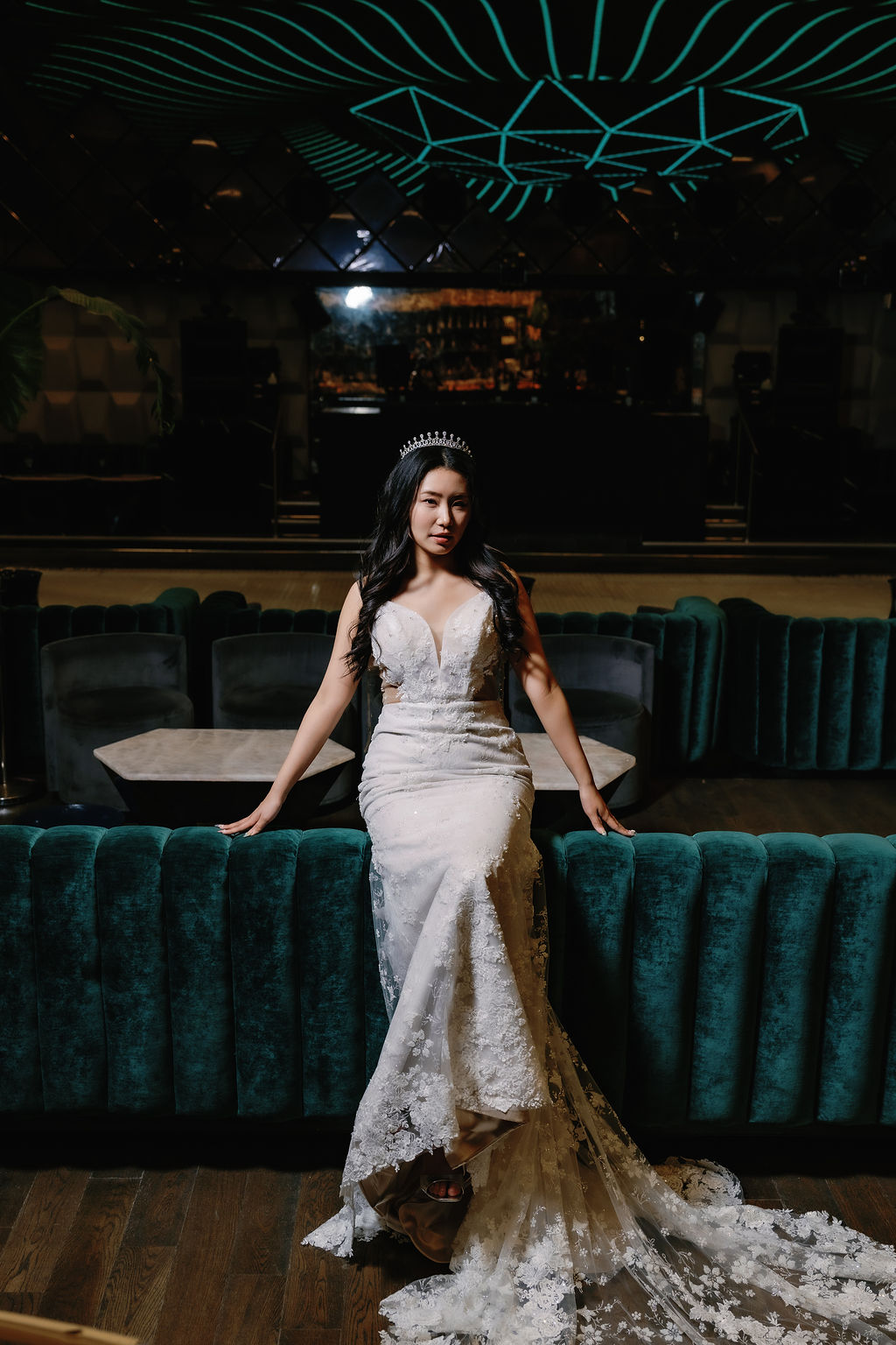 Bride sits atop teal velvet couch at Paradox Vancouver
