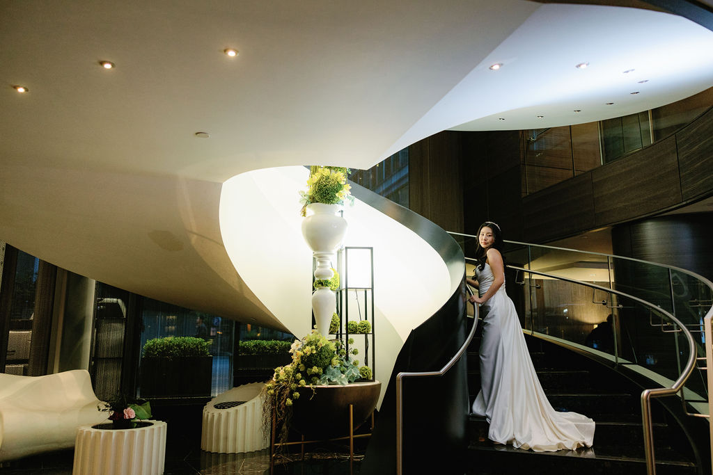 Bride looks up at Paradox Vancouver lobby decor